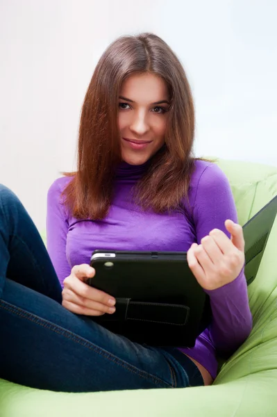 Mutlu genç güzel kadın evde, gülümseyerek ve onun tablet c kullanarak — Stok fotoğraf