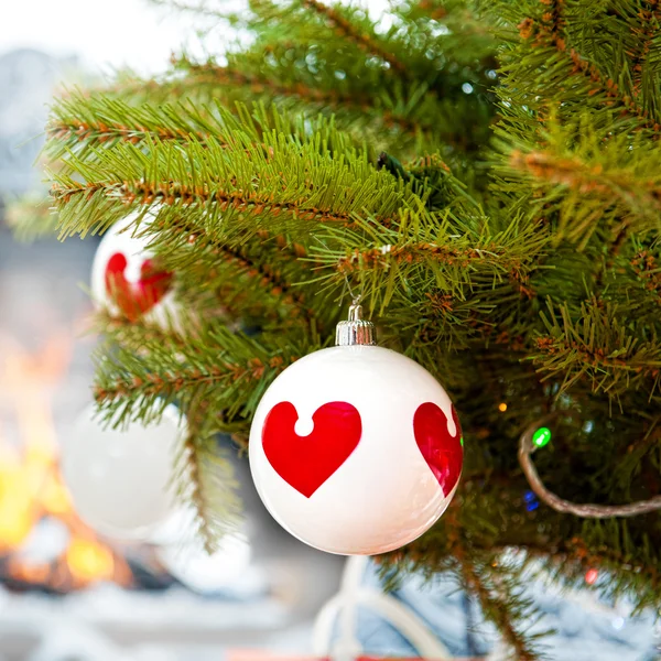 Christmas baubles against burning flame in fireplace on christma — Stock Photo, Image
