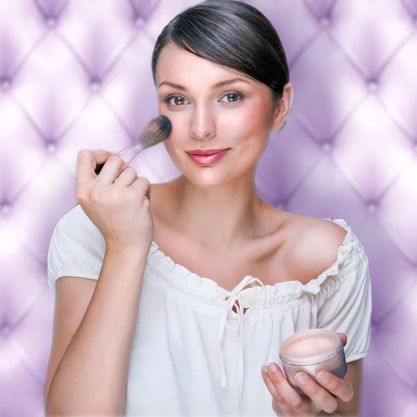Retrato de atraente jovem mulher adulta aplicando blusher agains — Fotografia de Stock