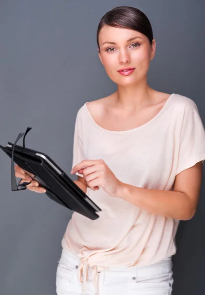 Retrato de una joven mujer bonita sosteniendo una tableta de computadora y vidrio —  Fotos de Stock