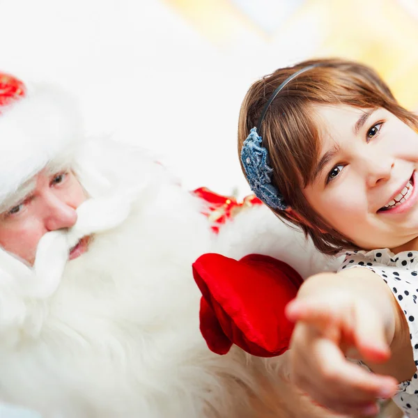 Weihnachtsthema: Weihnachtsmann und kleines Mädchen haben Spaß. — Stockfoto