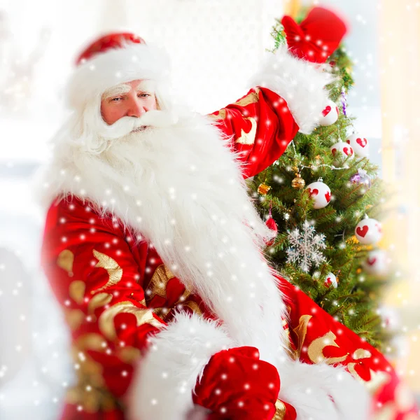 Babbo Natale seduto all'albero di Natale, vicino al camino e guardando — Foto Stock