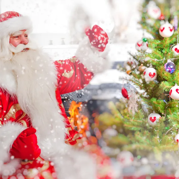 Santa sentado en el árbol de Navidad, cerca de la chimenea y mirando — Foto de Stock
