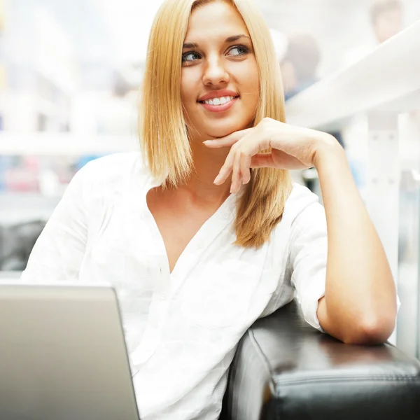 Retrato de la mujer rubia feliz usando el ordenador portátil en el centro comercial café — Foto de Stock