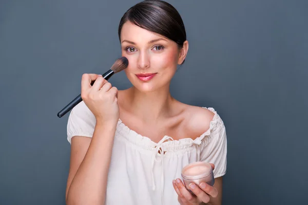 Portrét krásné ženy s make-up štětcem u její tvář lo — Stock fotografie