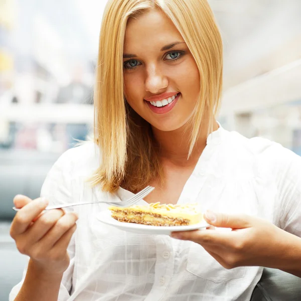 Retrato de jovem muito sorridente mulher comer bolo no shopping m — Fotografia de Stock