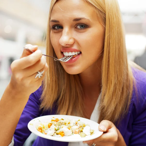 Retrato de cerca de una atractiva joven que come ensalada de frutas —  Fotos de Stock