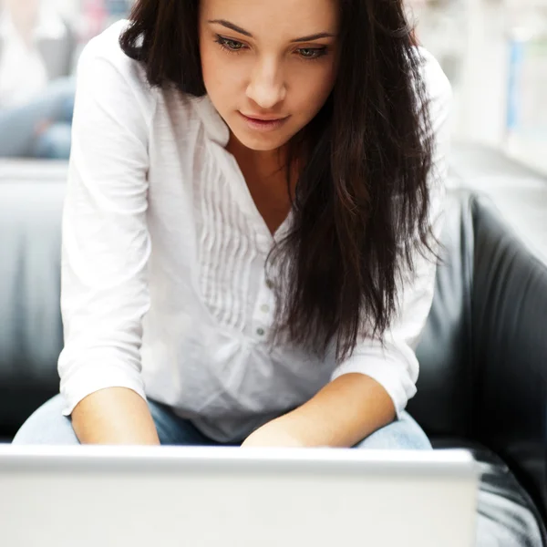 Portret to piękna młoda kobieta pracuje na laptopie podczas sitt — Zdjęcie stockowe