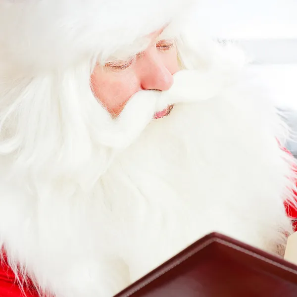 圣诞老人坐在家里和读一本书。在室内 — 图库照片