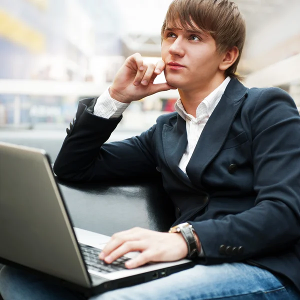 Portret przystojny młody mężczyzna pracujący z laptopa w kawiarni w bu — Zdjęcie stockowe