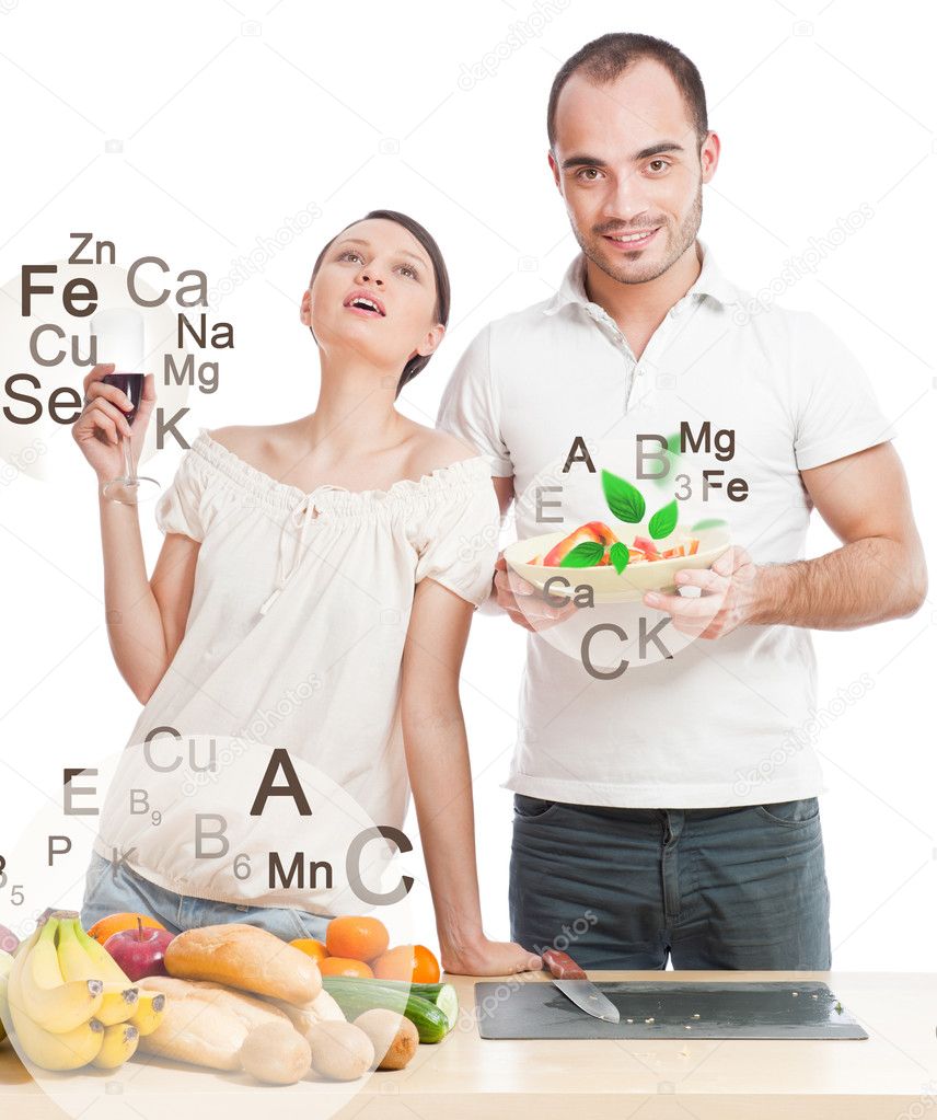 Playful young couple preparing healthy food and drinking wine is