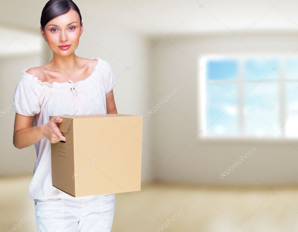 Smiling woman at her home holding boxes. She is Moving at her ne