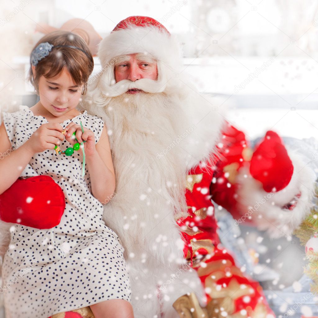 Christmas theme: Santa Claus and little girl having a fun.