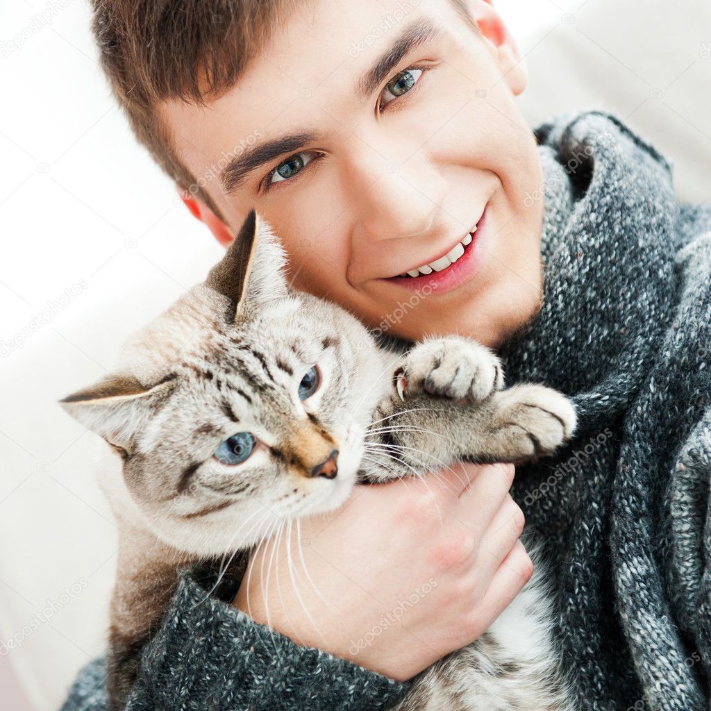 Relaxed man sitting on armchair holding and petting pet cat