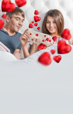 Closeup portrait of a happy young couple relaxing on the bed. Ma clipart