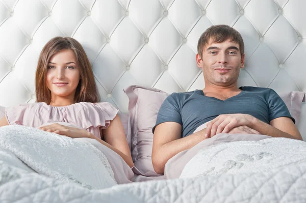 Mladý pár v jejich posteli přemýšlet o něčem — Stock fotografie