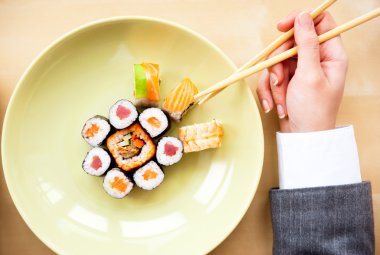 Top view of young business woman wearing suit holding sushi stic clipart