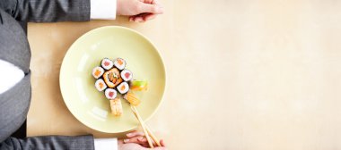 Top view of young business woman wearing suit holding sushi stic clipart