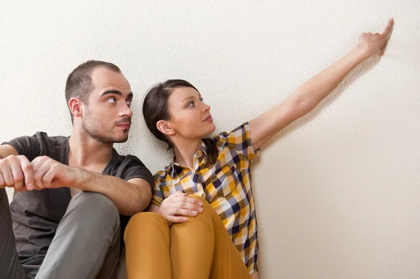 Attraktive junge erwachsene Paar sitzt in der Nähe auf dem Boden in Haus smi — Stockfoto