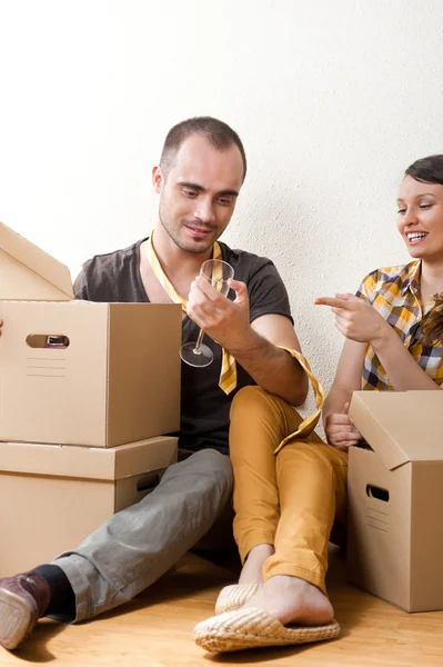 Young Couple with boxes in the new apartment sitting on floor an — Stock Photo, Image