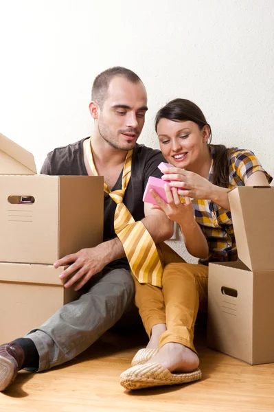 Молодая пара с коробками в новой квартире сидит на полу — стоковое фото