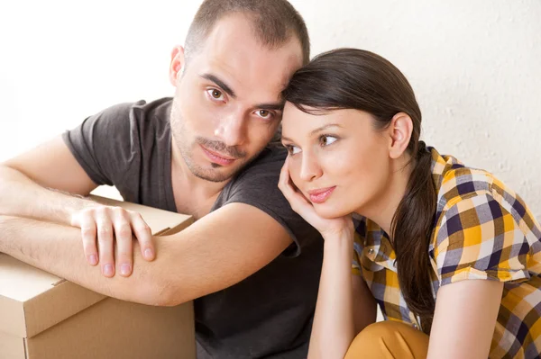 젊은 부부와 함께 바닥에 앉아 새 아파트에서 상자는 — 스톡 사진