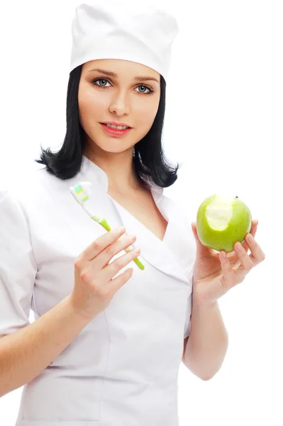 Beautiful young female dentist doctor with a toothbrush and gree Stock Image