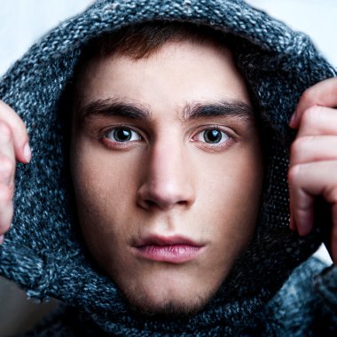 Portrait of young handsome man putting on warm pullover and look clipart
