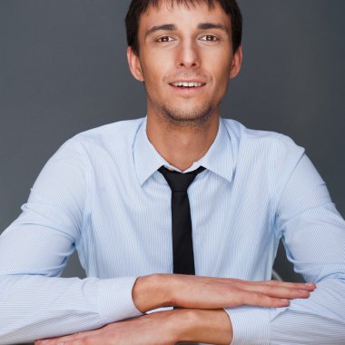 Portrait of young business man on a desk. He is sitting at his n clipart