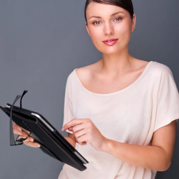 Portrét mladé hezké ženy drží tabletový počítač a sklo — Stock fotografie