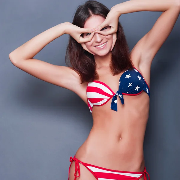 20-25 anni bella donna in costume da bagno con bandiera americana a — Foto Stock