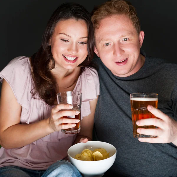 Happy couple sitting together watching something intresting on t — Stock Photo, Image