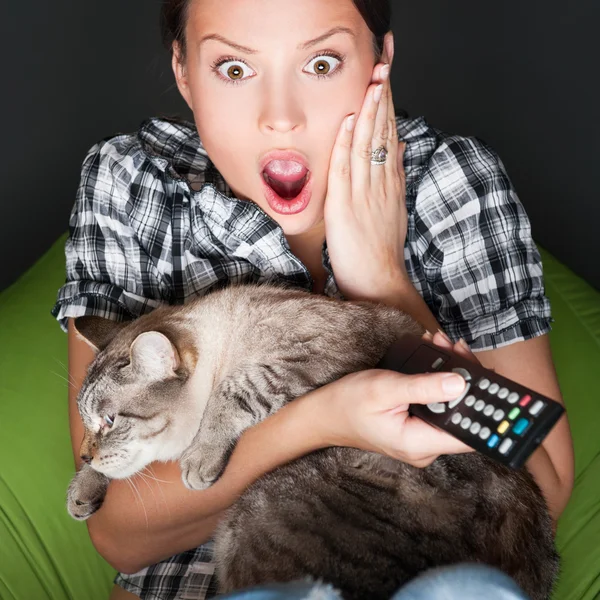Joven mujer divertida sentada en su bolsa de frijoles y abrazando a su gato w —  Fotos de Stock