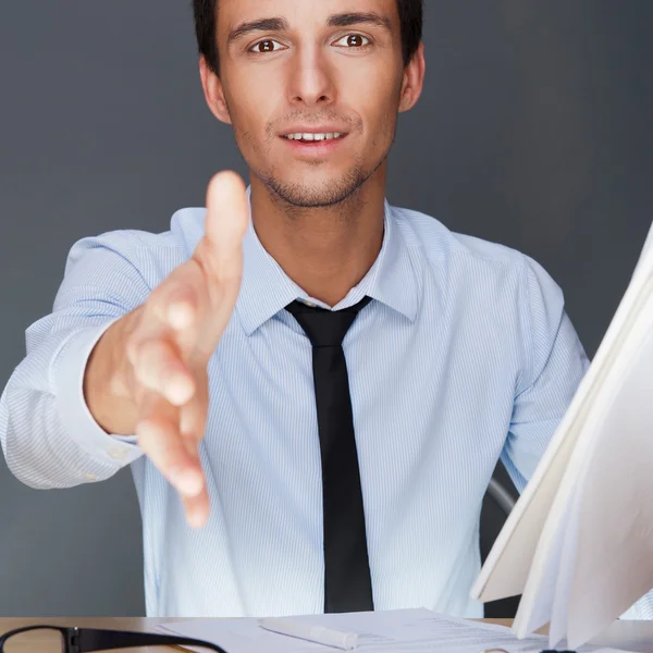 Portrait of an adult business man sitting in the office and hold — Stock Photo, Image