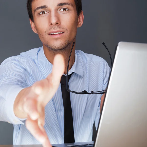 Geschäftsmann reicht Handschlag. sitzt in der Nähe seines Laptops an seinem de — Stockfoto