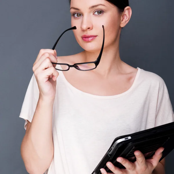 Retrato de una joven mujer bonita sosteniendo una tableta de computadora y vidrio — Foto de Stock