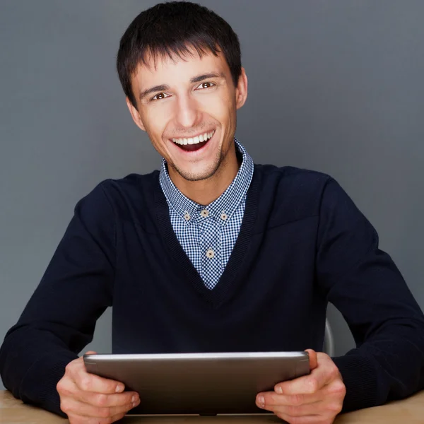 Primo piano di un giovane uomo d'affari sorridente seduto al suo ufficio ag — Foto Stock