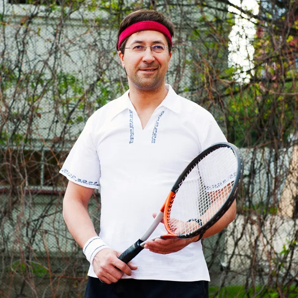 Mogen man spelar tennis på sin bakgård i hans hus — Stockfoto
