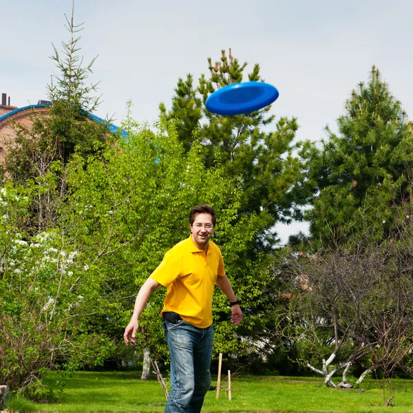 Muž hrát frisbee na svém dvorku — Stock fotografie