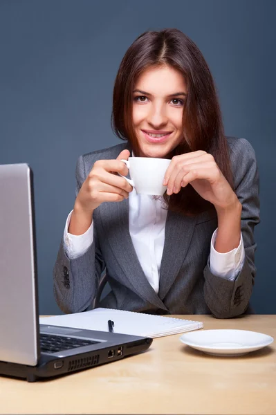 A pretty concentrated woman working with her laptop and papers. Sitting at — Stock Photo, Image