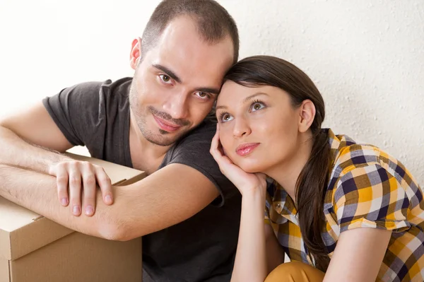 Νεαρό ζευγάρι με τα κιβώτια στο νέο διαμέρισμα κάθεται στο πάτωμα και σχεδιασμού — Φωτογραφία Αρχείου