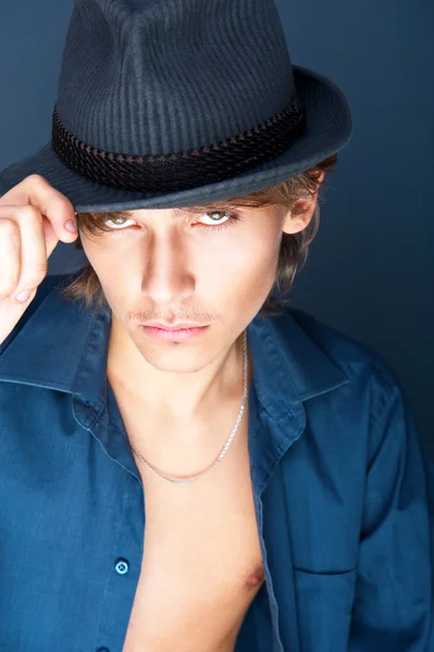 Joven hombre guapo con sombrero retro posando a la cámara — Foto de Stock