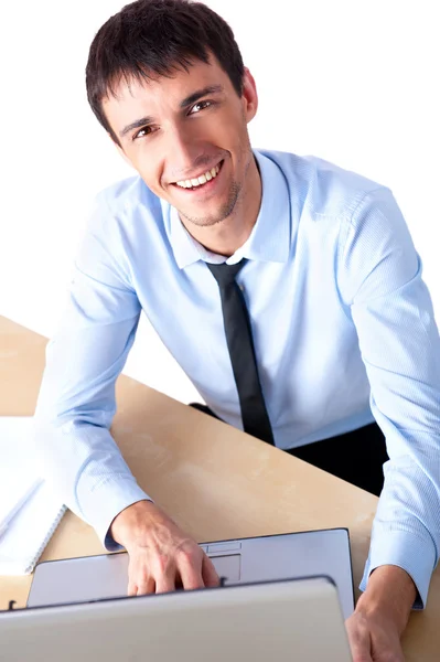 Привлекательный молодой человек, работающий с ноутбуком в своем офисе — стоковое фото