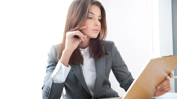 Porträt einer jungen Geschäftsfrau in einem Büro mit Dokumenten auf dem Arm — Stockfoto