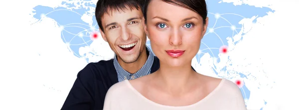 Handsome friendly couple in futuristic interface standing in front of world map with glowing hot points location and connection lines — Stock Photo, Image