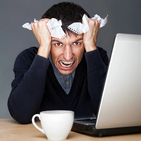 Primo piano di un giovane uomo d'affari arrabbiato che soffre di stress. Mal di testa. Sullo sfondo grigio — Foto Stock