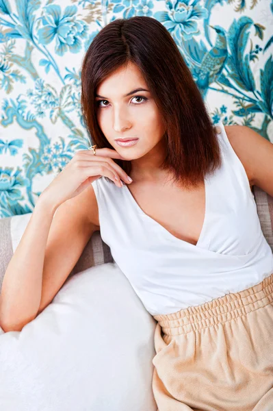 Portrait of happy young woman sitting on sofa at her home — Stock Photo, Image