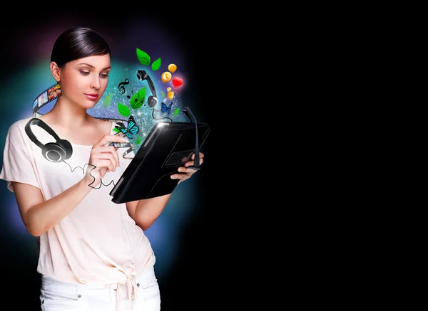 Posterporträt einer jungen schönen Frau, die ihr Universalgerät - Tablet-PC - in der Hand hält. Viele Dinge erscheinen aus dem Display. Universalität des Konzepts moderner Geräte — Stockfoto