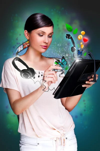 Poster portrait of young beautiful woman holding her universal device - tablet pc. Lots of things are appearing from the display. Universality of modern devices concept — Stock Fotó