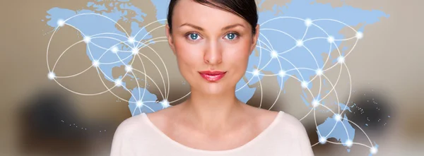 大きな世界地図の前に立って、カメラを見て、若い女性の肖像画。サーバーの場所と実際にオンライン接続仮想マップ上に表示されます。ホスティング プロバイダーの概念 — ストック写真
